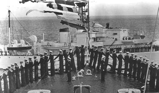 Royal Yacht Surprise passes the bows of HMS Vanguard