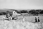 A Naval helicopter landing in an olive grove on the island of Zante. The helicopter was taking food supplies to villages cut off from the rest of the island. Villagers are seen running to the helicopter for food, August 1953. Image from Imperial War Museums, A32666