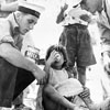 A British sailor and an American Marine join forces to feed the refugees, August 1953. Image from Imperial War Museums, A32693
