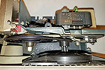 Looking down, a shaft from the motor runs through a backing plate to a small pulley and then on to the fan.